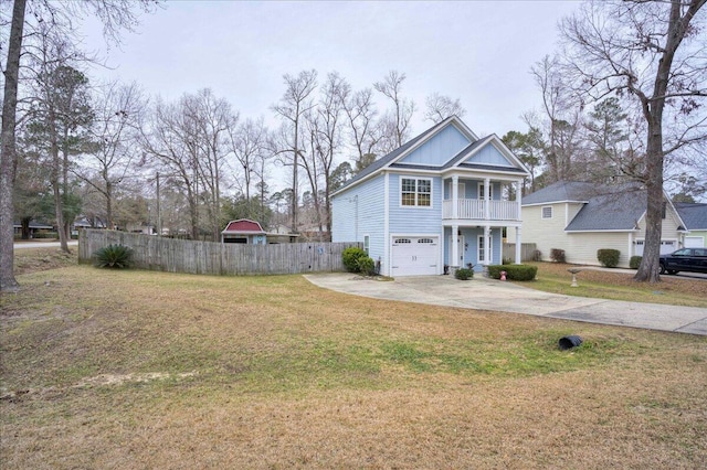 view of front facade with a balcony, a front lawn, and a garage