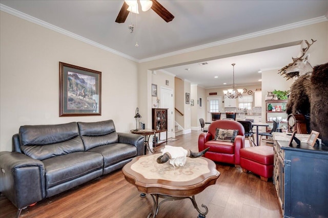 living room featuring sink, hardwood / wood-style floors, ceiling fan with notable chandelier, and ornamental molding