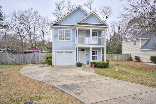 view of front of home featuring a balcony, a front yard, and a garage