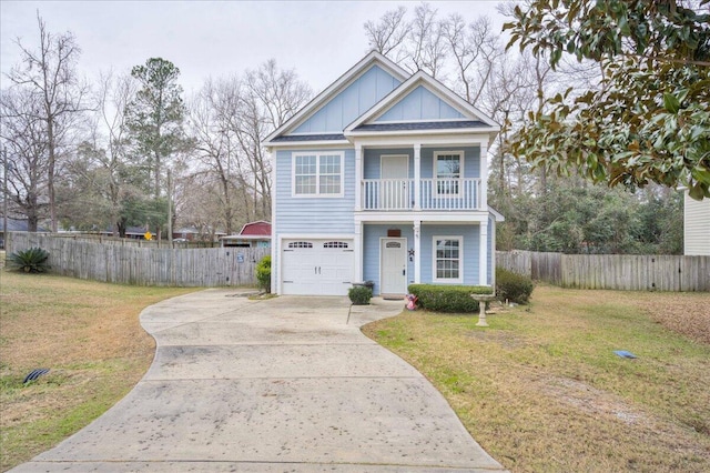 view of front of home featuring a balcony, a front yard, and a garage