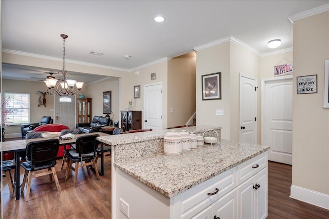 kitchen with ornamental molding, decorative light fixtures, white cabinetry, and dark wood-type flooring