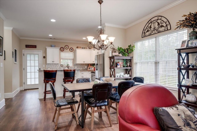 dining area with a notable chandelier, dark hardwood / wood-style flooring, and crown molding