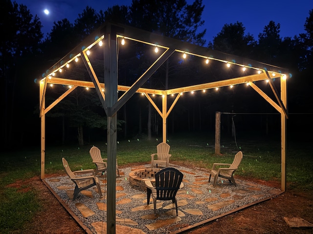 2061 White Rock Rd, Lincolnton, GA 30817 - patio at night with an outdoor fire pit, a patio, and a lawn