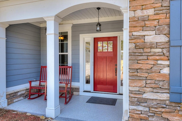 property entrance featuring stone siding and a porch