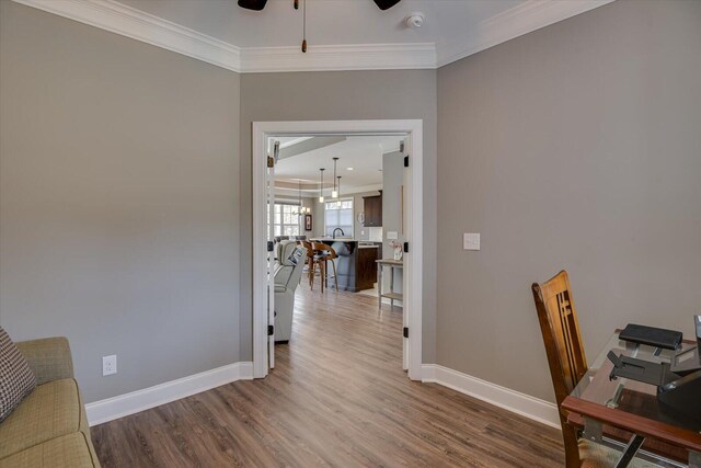 home office with ceiling fan, crown molding, baseboards, and wood finished floors