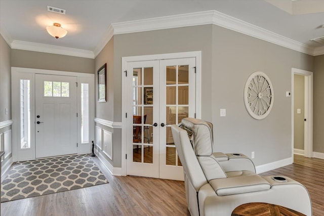 foyer with wood finished floors, visible vents, baseboards, french doors, and crown molding