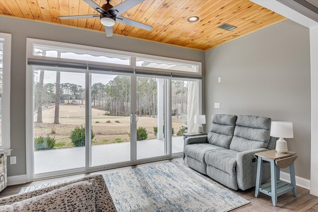 living area featuring a ceiling fan, wood ceiling, baseboards, and wood finished floors