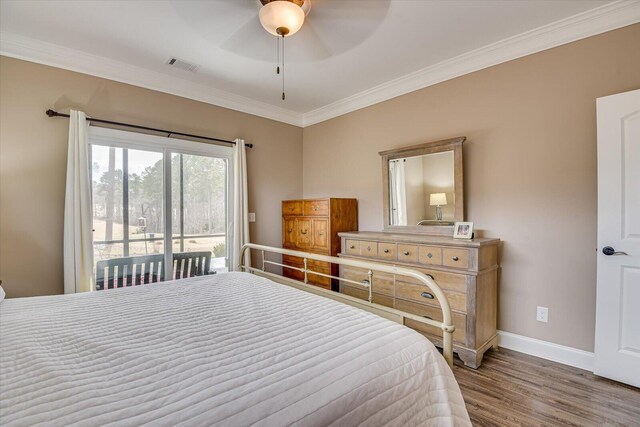 bedroom featuring wood finished floors, visible vents, baseboards, access to outside, and ornamental molding