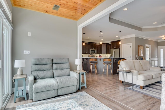 living area with recessed lighting, visible vents, light wood-style flooring, ornamental molding, and wooden ceiling