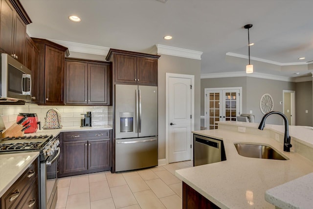 kitchen with french doors, stainless steel appliances, backsplash, a sink, and light stone countertops