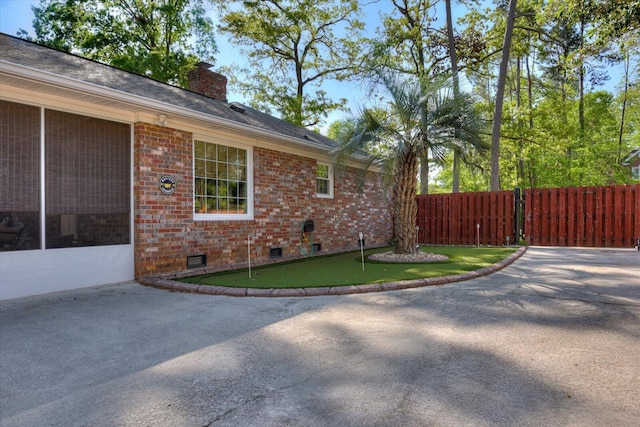 3215 Ramsgate Rd, Augusta, GA 30909 - view of property exterior featuring an area to practice putting, crawl space, fence, brick siding, and a chimney