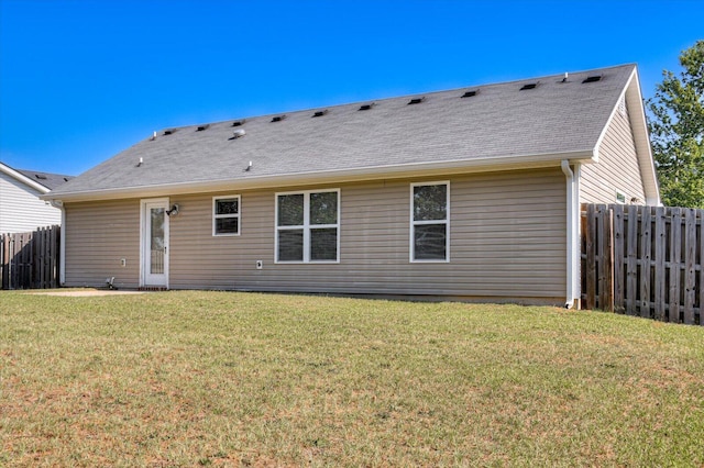 back of house with a lawn