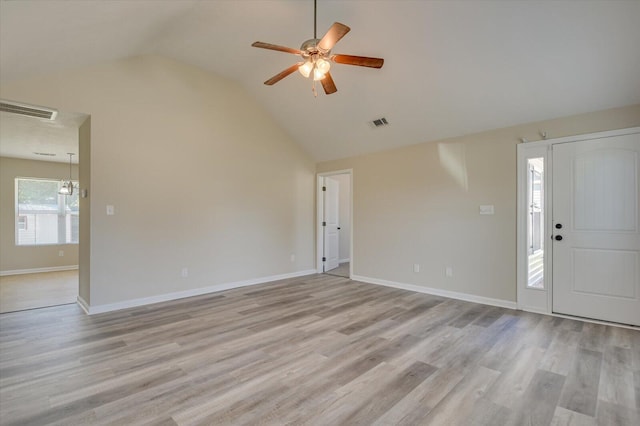 foyer with ceiling fan with notable chandelier, light hardwood / wood-style floors, and lofted ceiling