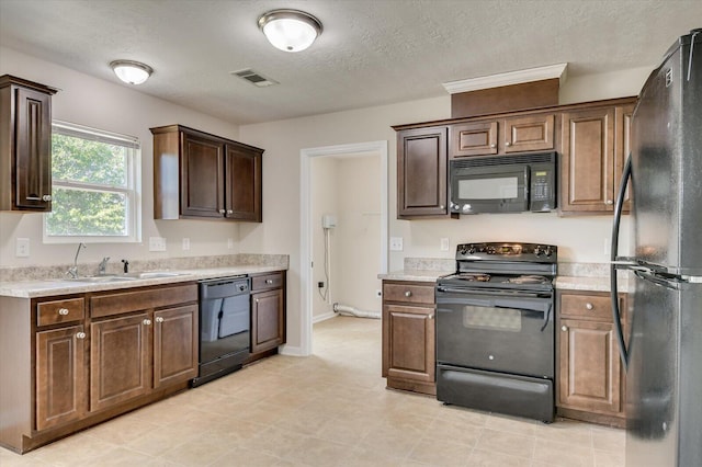 kitchen with black appliances, dark brown cabinetry, sink, and a textured ceiling