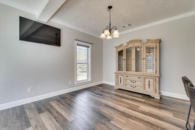 unfurnished dining area featuring a chandelier, hardwood / wood-style floors, and a textured ceiling