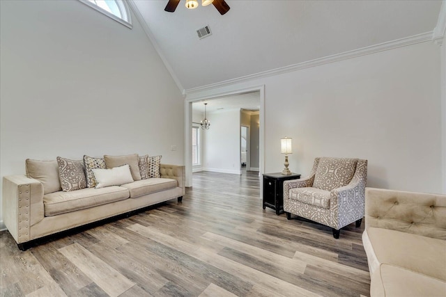 living room with crown molding, high vaulted ceiling, ceiling fan with notable chandelier, and hardwood / wood-style floors