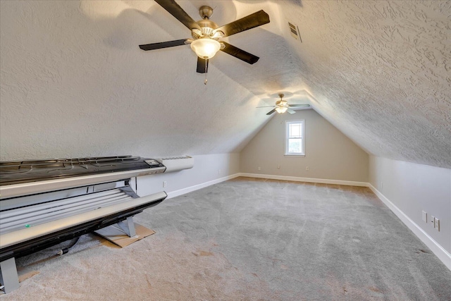 bonus room featuring light colored carpet, lofted ceiling, and a textured ceiling