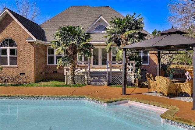 view of pool with a gazebo, french doors, and a deck