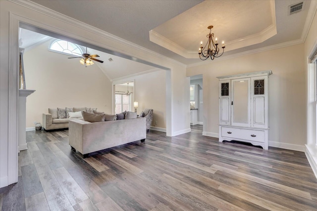 living room with vaulted ceiling, dark hardwood / wood-style floors, ceiling fan with notable chandelier, a raised ceiling, and crown molding