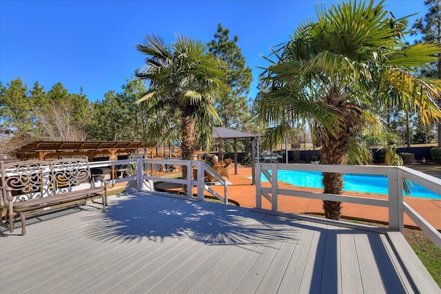 wooden deck featuring a gazebo and a fenced in pool