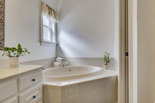 bathroom featuring vanity and tiled tub