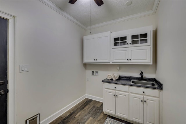 laundry area featuring sink, hookup for a washing machine, dark hardwood / wood-style floors, ornamental molding, and a textured ceiling