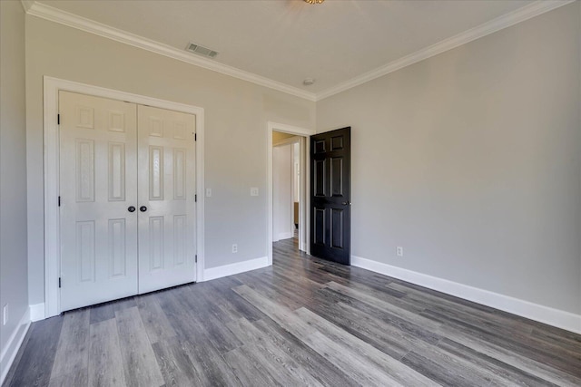 unfurnished bedroom with wood-type flooring, ornamental molding, and a closet