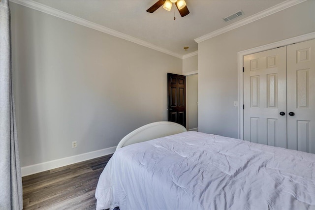 bedroom with a closet, crown molding, dark hardwood / wood-style floors, and ceiling fan