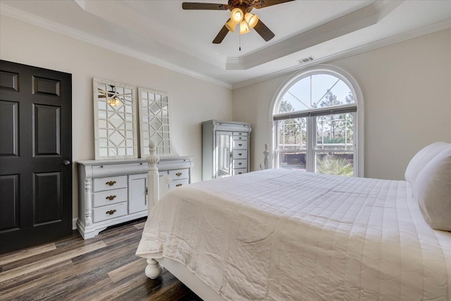 bedroom with crown molding, ceiling fan, a raised ceiling, and hardwood / wood-style floors