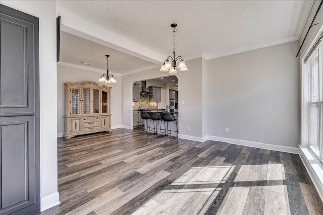 unfurnished living room featuring crown molding, a notable chandelier, hardwood / wood-style flooring, and sink