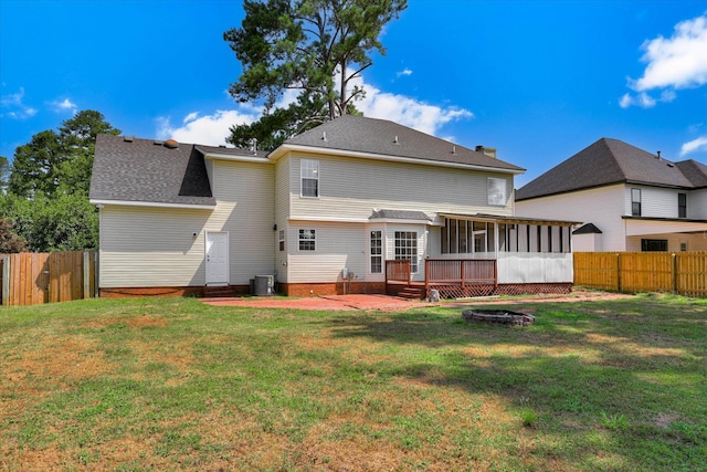 4142 Quinn Dr, Evans, GA 30809 - rear view of house featuring a sunroom, a fenced backyard, a deck, a shingled roof, and an outdoor fire pit