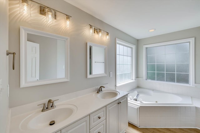 4142 Quinn Dr, Evans, GA 30809 - bathroom featuring a tub with jets, double vanity, and wood finished floors