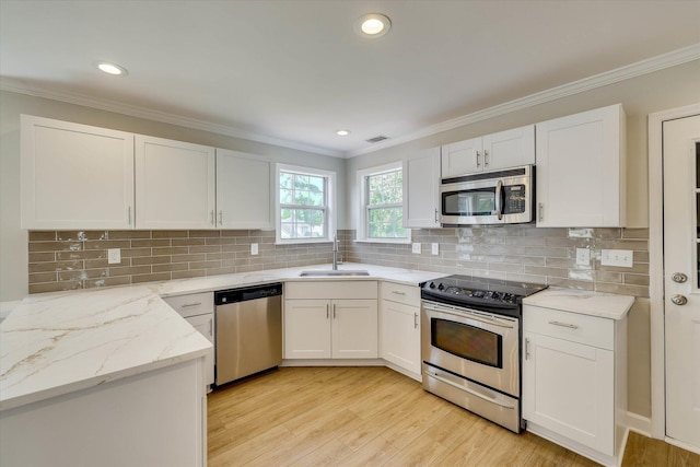 4142 Quinn Dr, Evans, GA 30809 - kitchen with stainless steel appliances, ornamental molding, white cabinetry, light stone counters, and light wood-type flooring