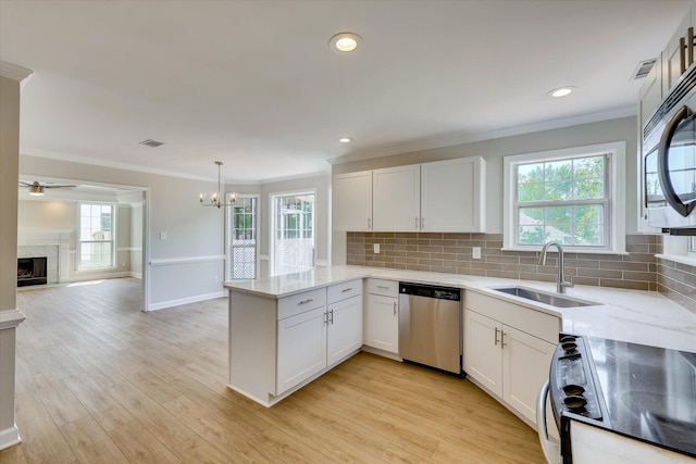 4142 Quinn Dr, Evans, GA 30809 - kitchen featuring stainless steel appliances, a peninsula, a ceiling fan, decorative backsplash, and a premium fireplace