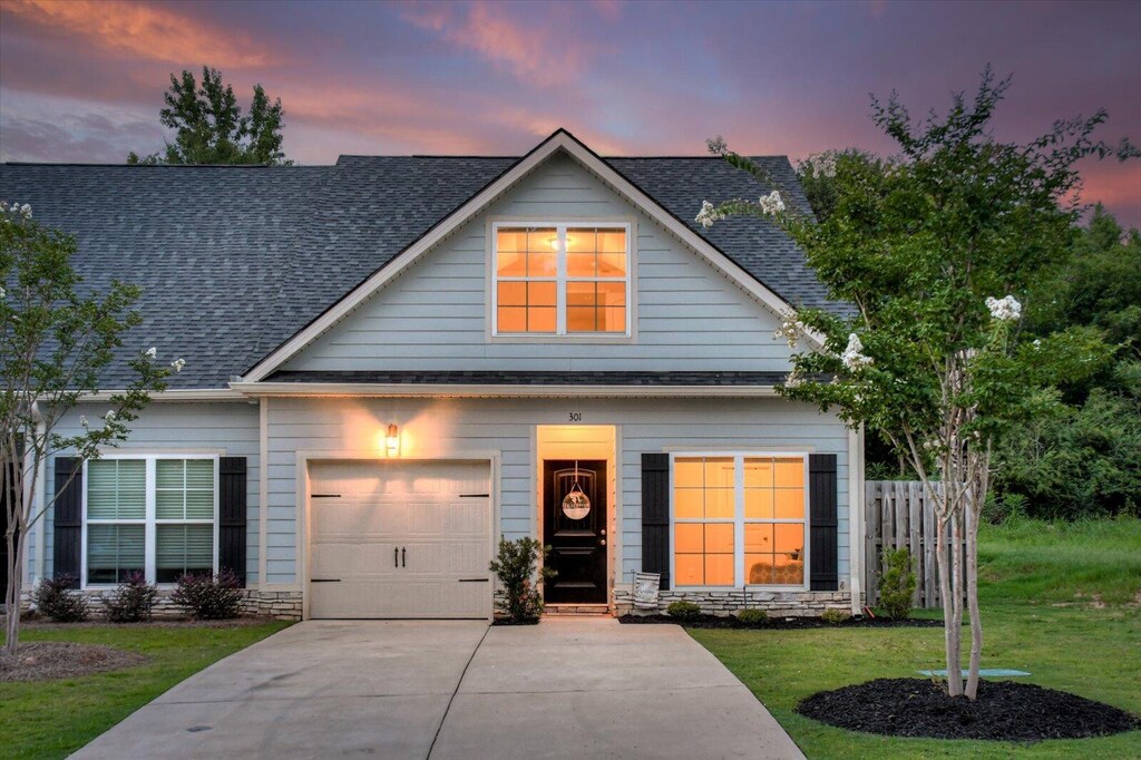 craftsman house with a garage and a lawn