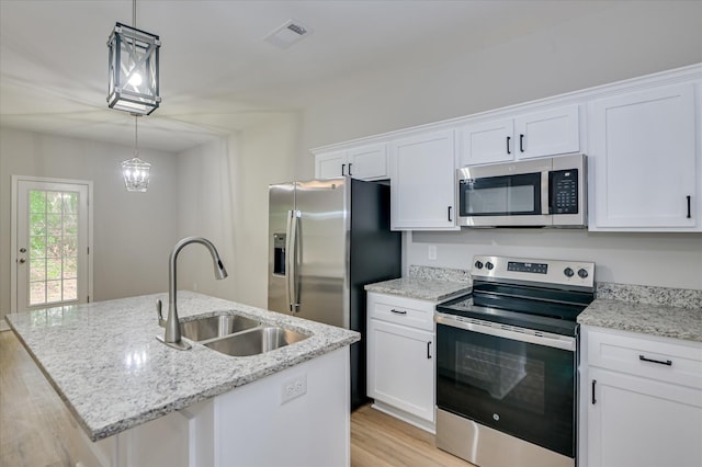 2815 Ridge Crest Dr, Hephzibah, GA 30815 - kitchen featuring appliances with stainless steel finishes, a sink, light wood finished floors, white cabinets, and a center island with sink