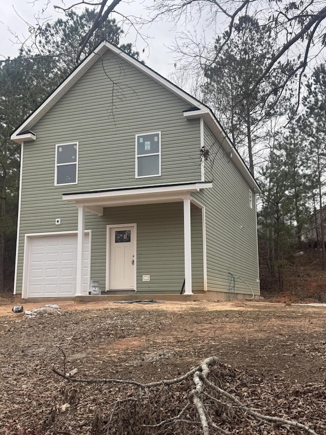 rear view of house featuring an attached garage