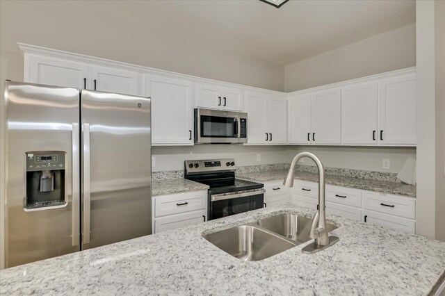 2815 Ridge Crest Dr, Hephzibah, GA 30815 - kitchen with stainless steel appliances, a sink, white cabinets, and light stone counters