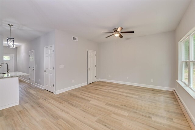 2815 Ridge Crest Dr, Hephzibah, GA 30815 - unfurnished living room featuring plenty of natural light, light wood-style flooring, a ceiling fan, and baseboards