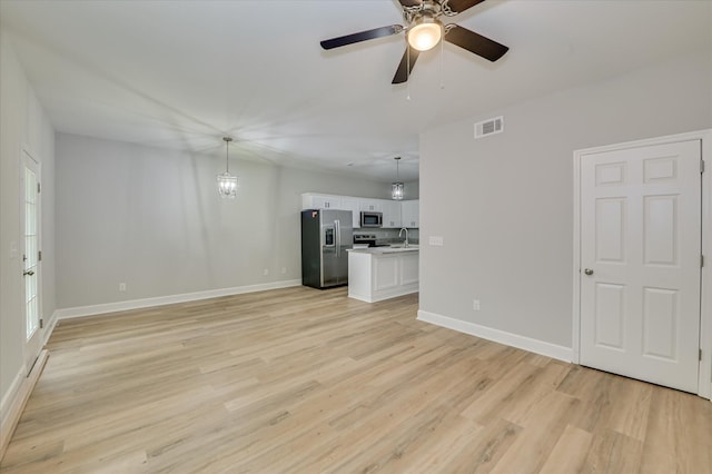 2815 Ridge Crest Dr, Hephzibah, GA 30815 - unfurnished living room with light wood finished floors, baseboards, a ceiling fan, and a sink