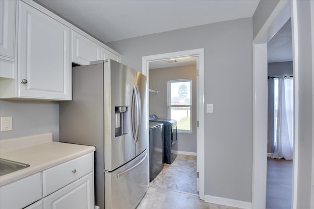 3643 Stanton Ct, Augusta, GA 30906 - kitchen featuring independent washer and dryer, white cabinetry, stainless steel fridge with ice dispenser, light countertops, and baseboards