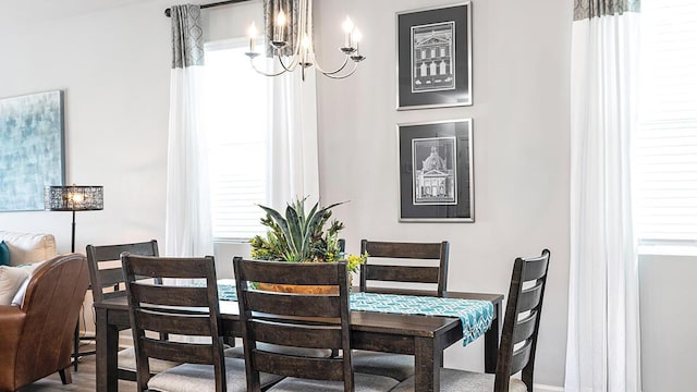 dining room with an inviting chandelier, a healthy amount of sunlight, and hardwood / wood-style floors