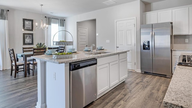 kitchen featuring sink, white cabinetry, decorative light fixtures, a notable chandelier, and stainless steel appliances