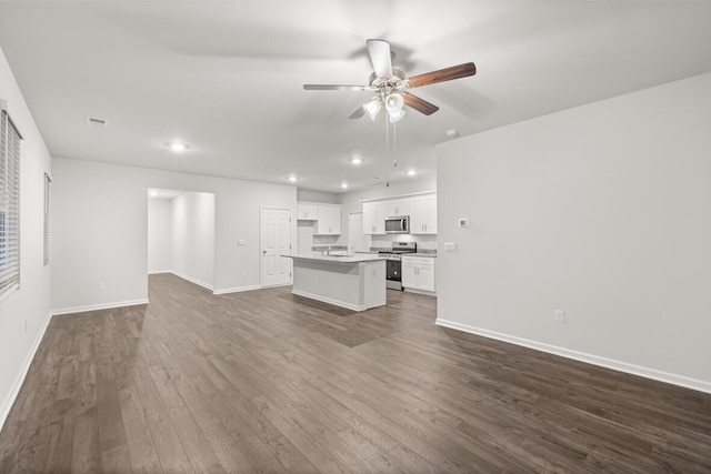 unfurnished living room featuring dark hardwood / wood-style floors and ceiling fan