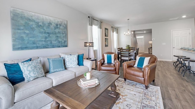 living room featuring an inviting chandelier and light hardwood / wood-style flooring