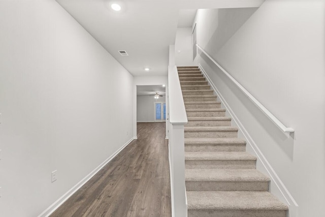 staircase with hardwood / wood-style flooring and ceiling fan