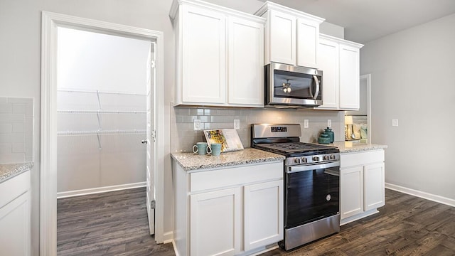 kitchen featuring light stone counters, stainless steel appliances, dark hardwood / wood-style floors, and white cabinets