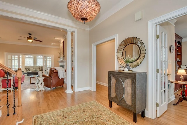 hallway featuring ornamental molding, light hardwood / wood-style floors, and decorative columns