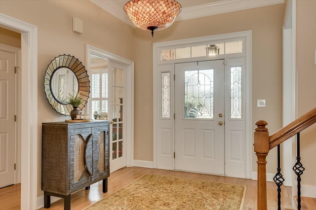 entrance foyer with hardwood / wood-style floors and ornamental molding