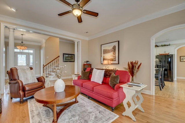 living room with light hardwood / wood-style floors, ceiling fan, and crown molding